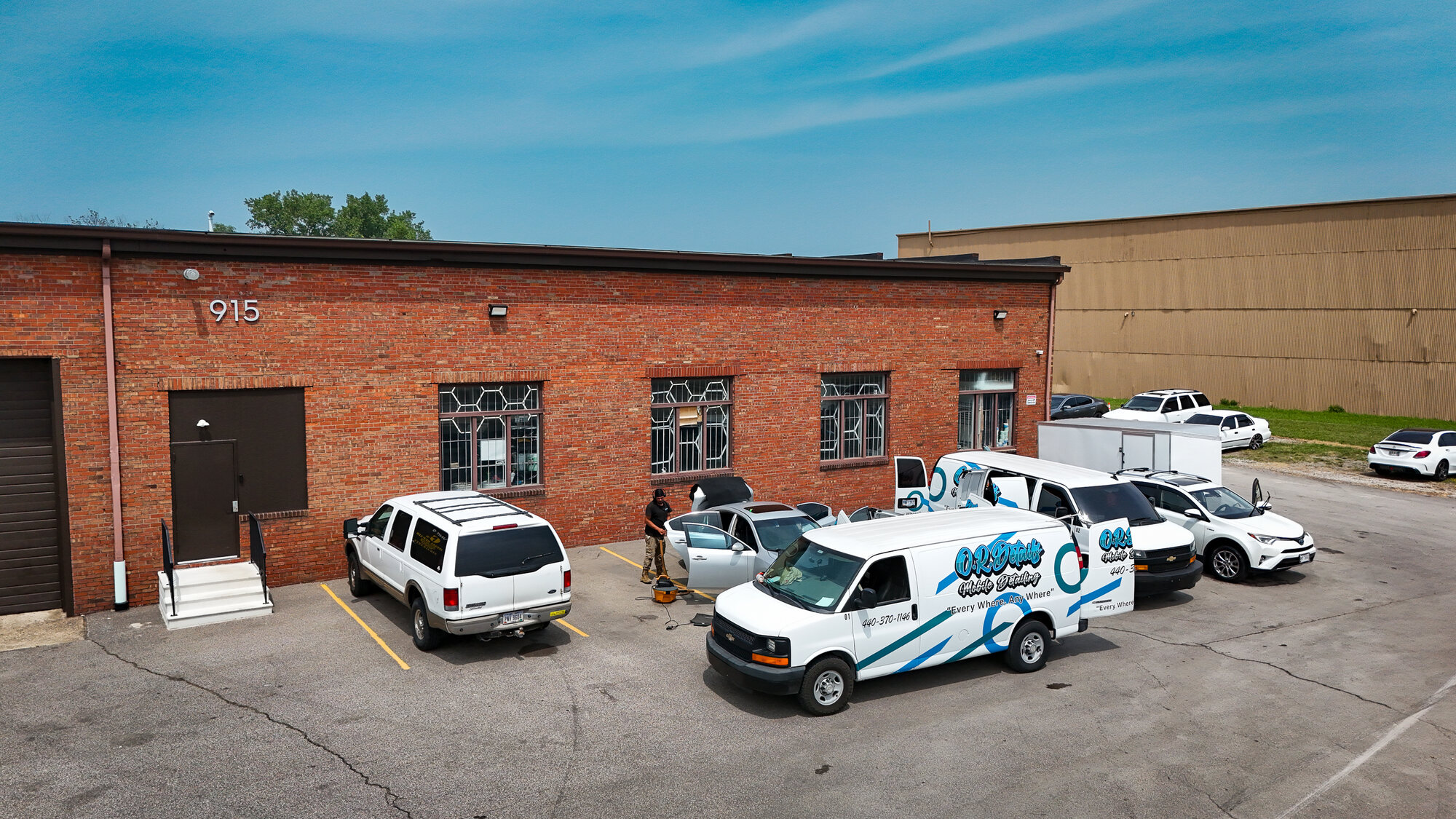 Aerial view of the O.R. Details shop at 915 Colorado Ave with branded fleet vans